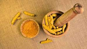 چوب زردچوبه اصل هندی ساییده شده در کاسه با رنگ نارنجی طبیعی