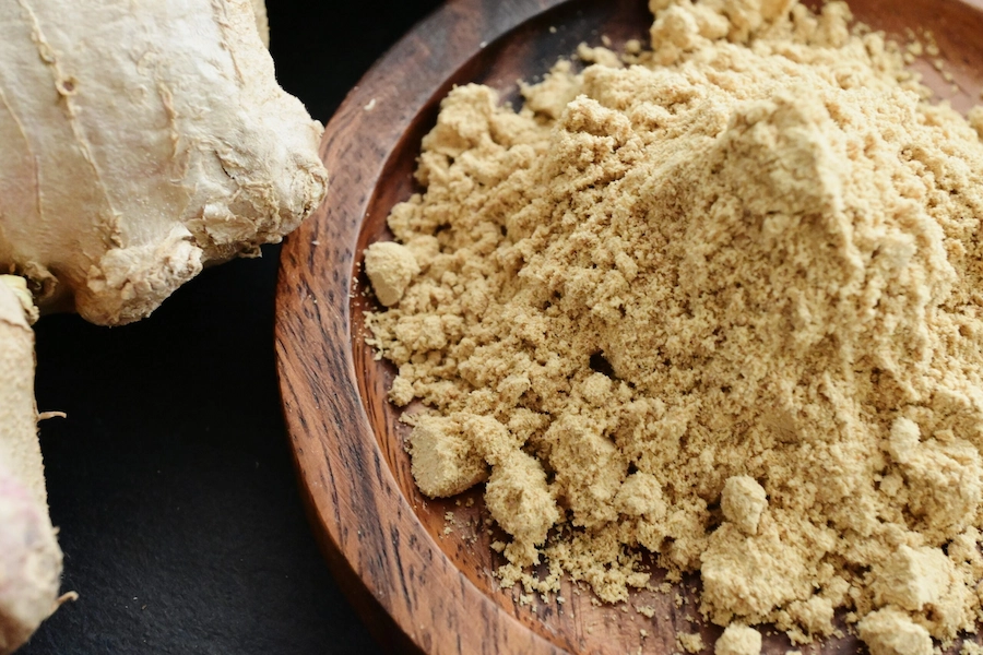پودر زنجبیل خالص در کاسه چوبی؛ یکی از ادویههای طبیعی تقویتکننده سیستم ایمنی بدن با عطر و طعم گرم، مناسب برای دمنوشها و انواع غذاها.